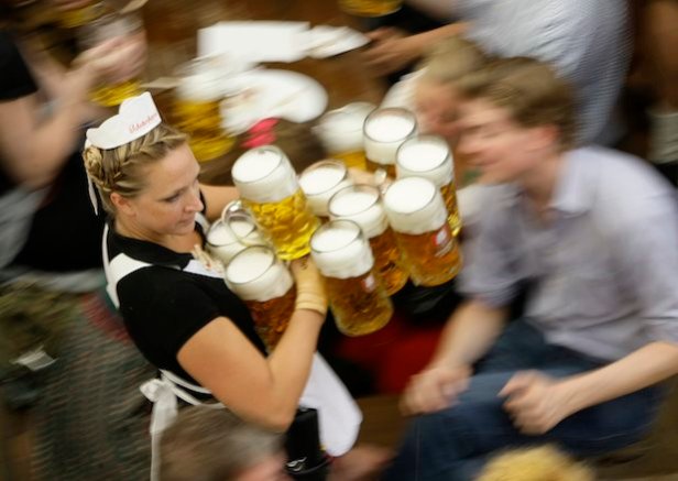 Waitress serves mugs of beer during 176th Oktoberfest in Munich